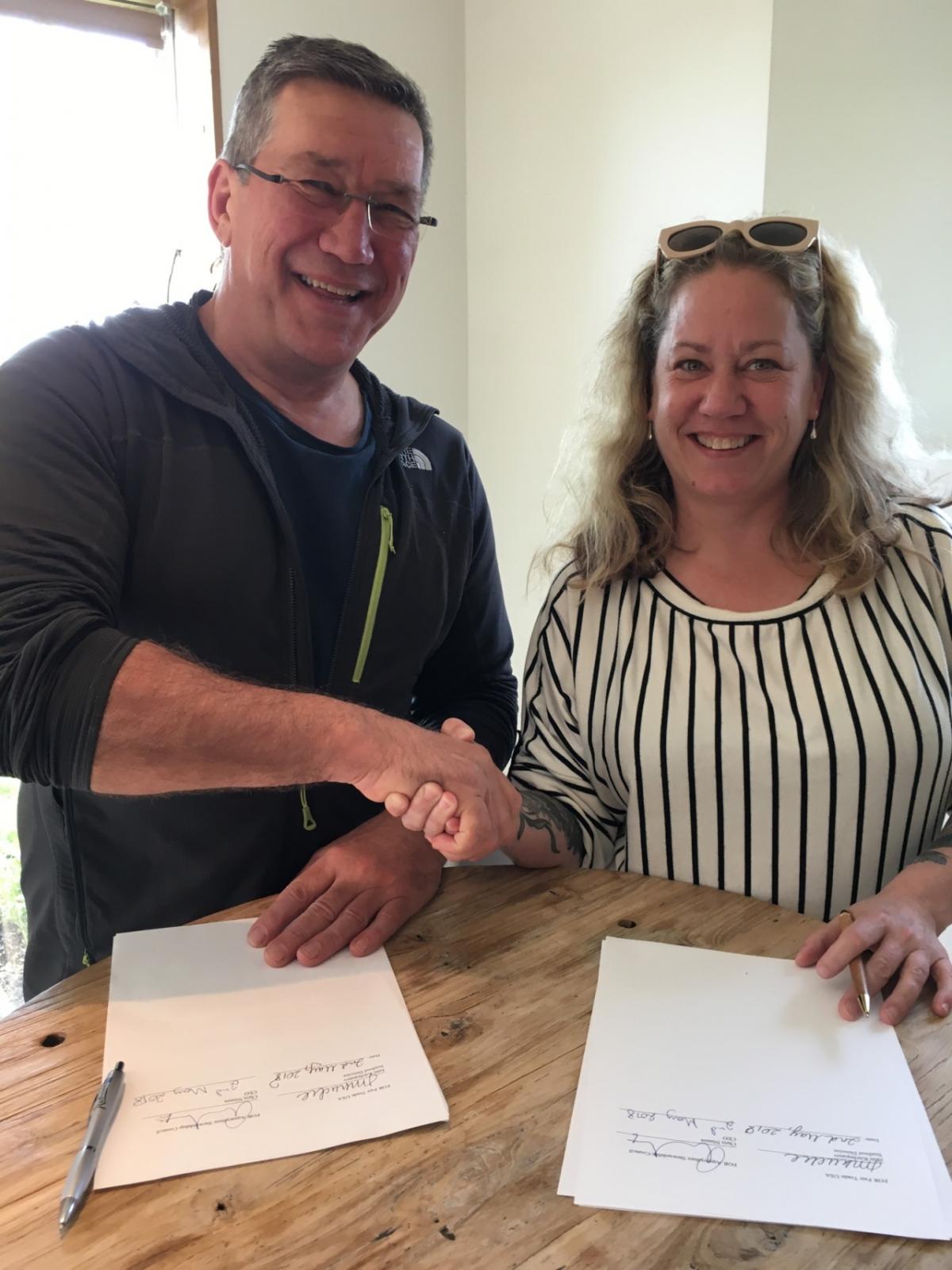 Chris Ninnes, CEO of the Aquaculture Stewardship Council, signs MOU with Julie Kuchepatov, Seafood Director of Fair Trade USA, to pilot Fair Trade USA’s requirements in some ASC-certified fish farms.