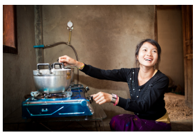 A person using a small cooktop with pot on it.