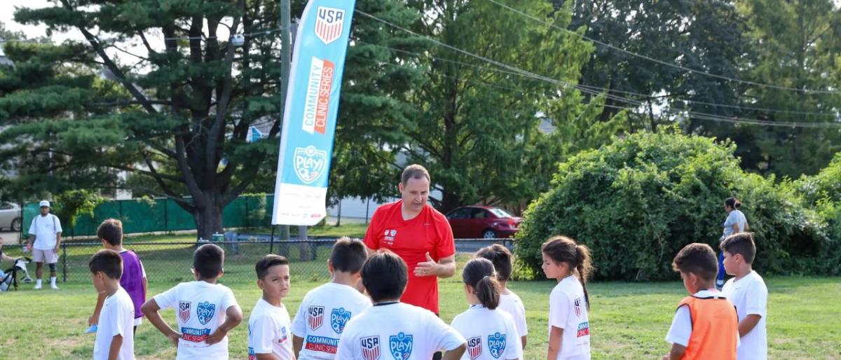 Coach speaking to kids at a soccer field