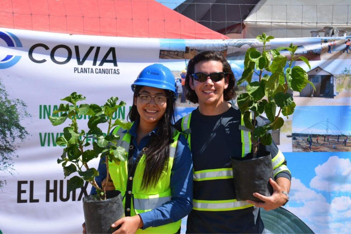 Abel and another posed with tree saplings.