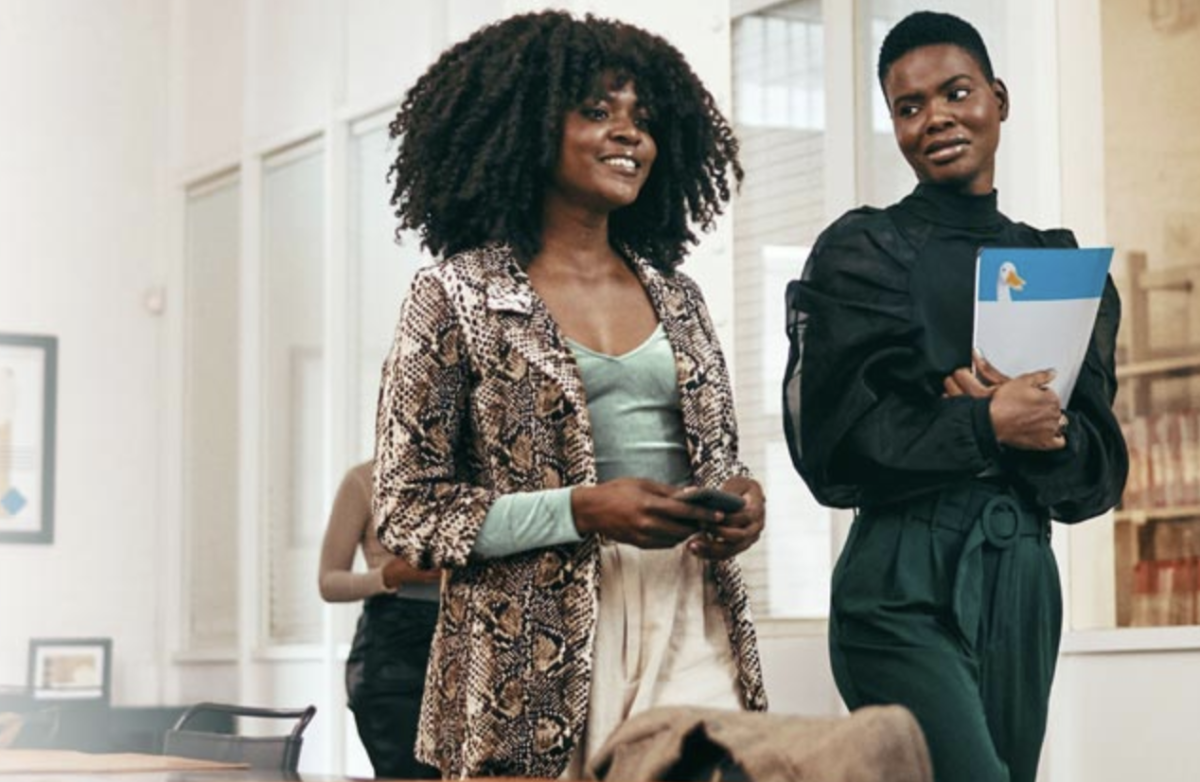 Two women of color walking through an office.