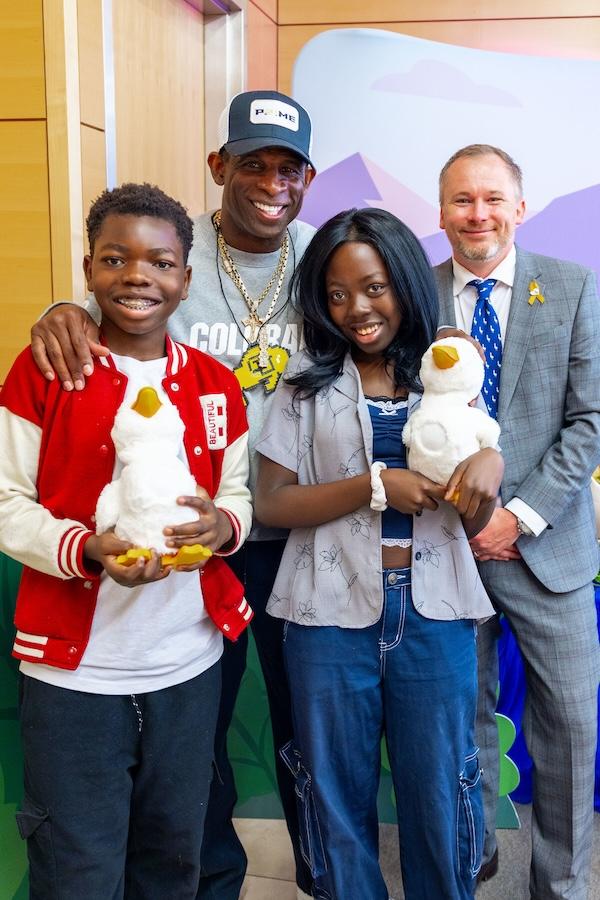 Deion "Coach Prime" Sanders Deion Sanders shown with young patients holding the Aflac Duck.