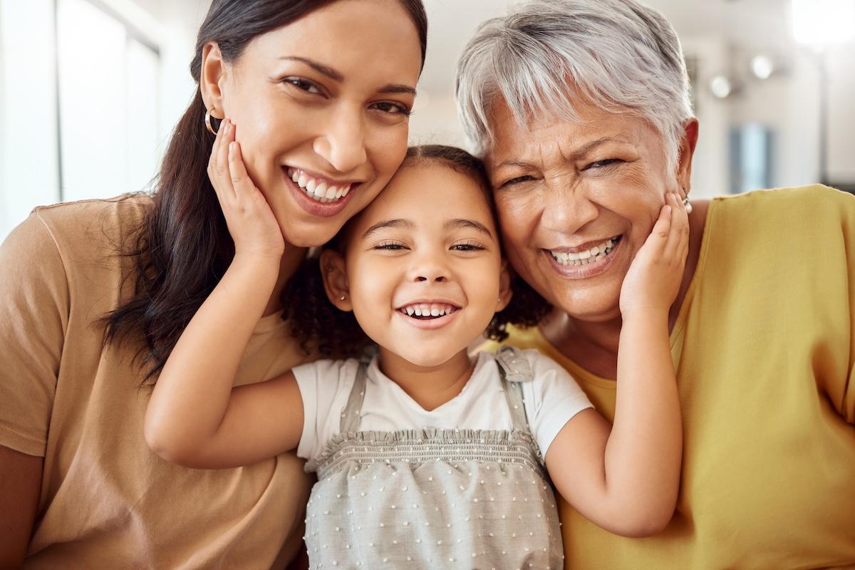 A mom, daughter and grandmother shown in a hug.