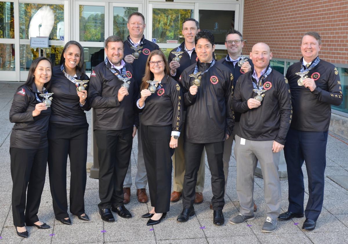 Aflac team members show their medals from the Marine Corps Marathon.