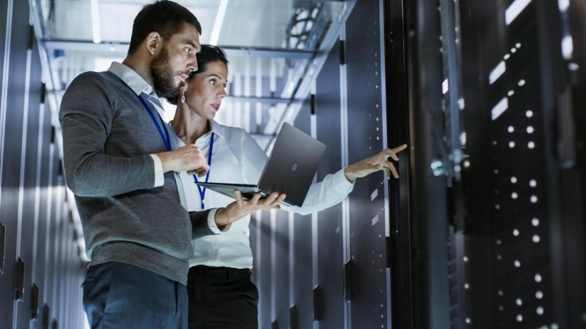 Two workers looking at a data center system