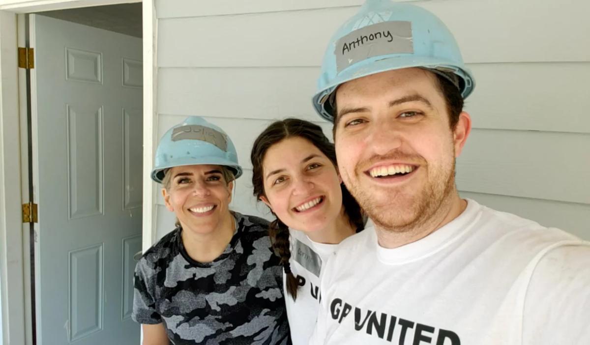 Anthony Reyna & wife at GP Build with Erin Beckman in front of a house.