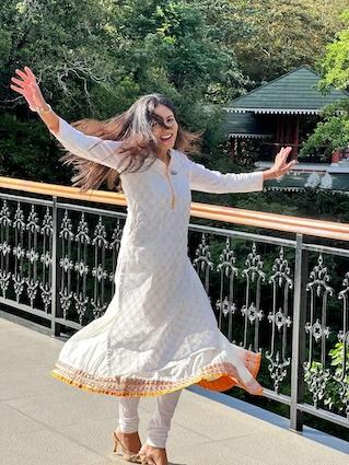 Ashwini dressed in a traditional Indian outfit crossing a bridge. 