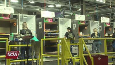 three workers assembling refrigerators 