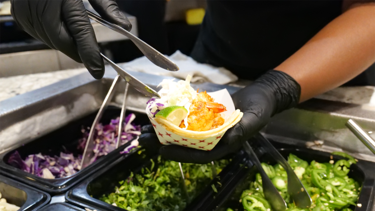 person serves fish tacos