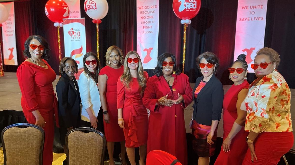 A group of people posed, each wearing red sunglasses.