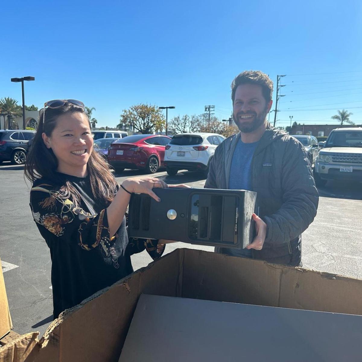 Man and woman placing computer in cardboard box