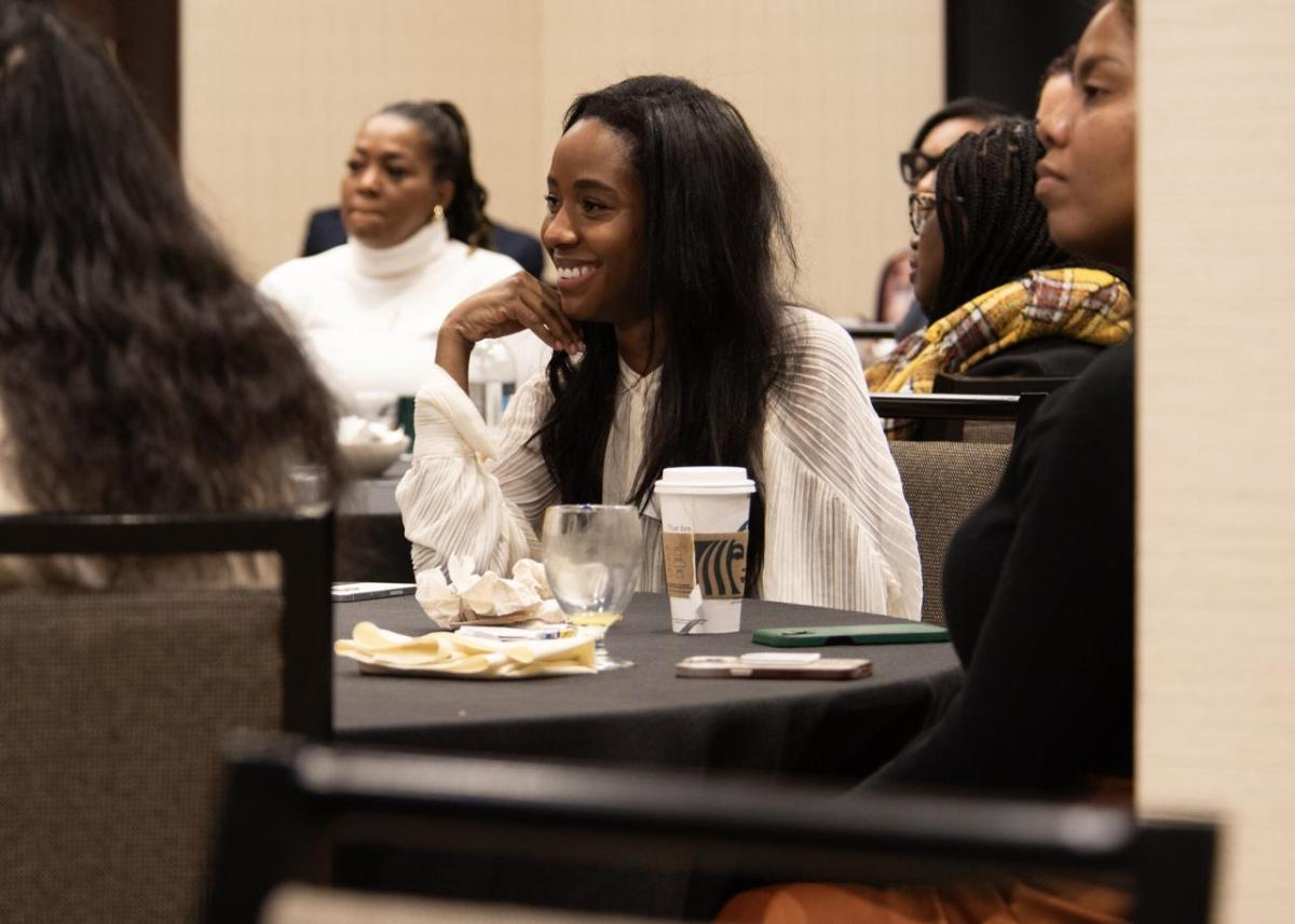 A smiling participant seated in a room of others