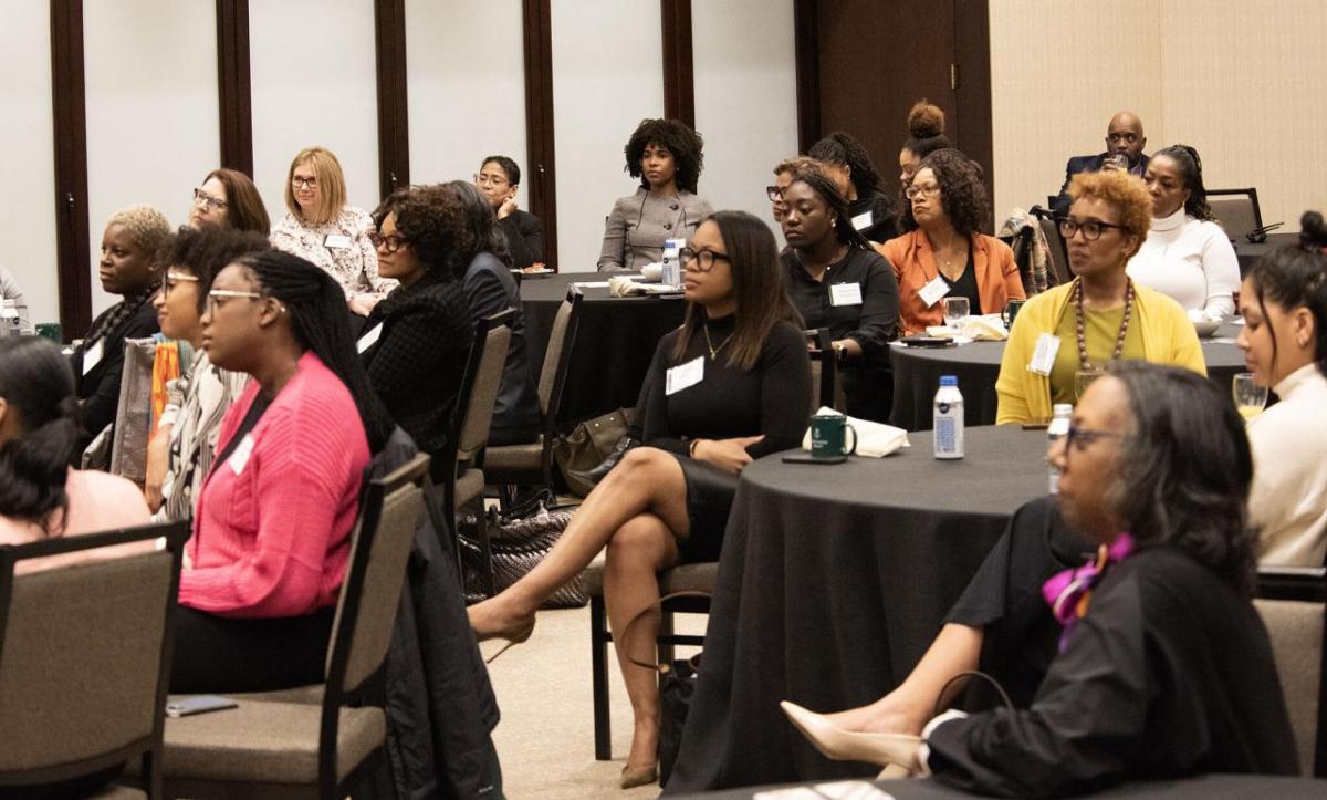 A room full of seated participants listening to a speaker