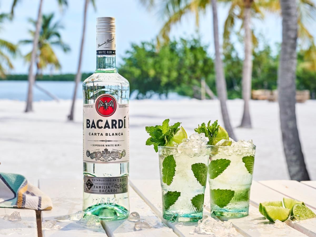 bottle of bacardi rum and cocktails with a beach in the background