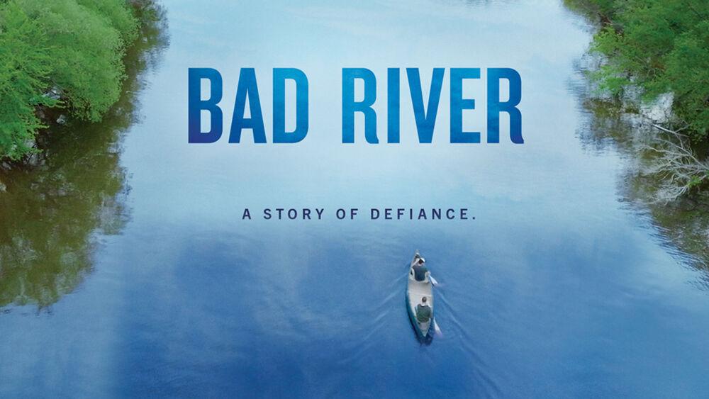 Two people in a canoe on a tree-lined river. "Bad River. A story of defiance."