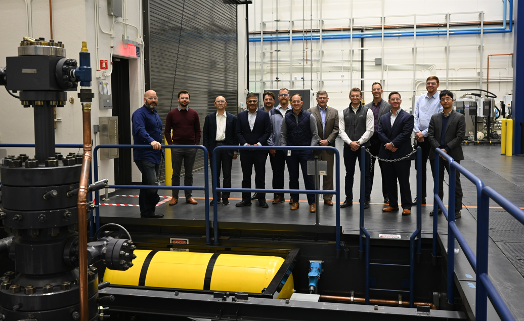 The Wells2Watts consortium board members stand next to the Baker Hughes laboratory test well that will be repurposed to evaluate the closed-loop geothermal system at the at the OSU Hamm Institute of American Energy, Oklahoma City, Okla.
