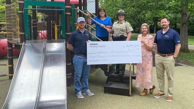 People posing with check at playground