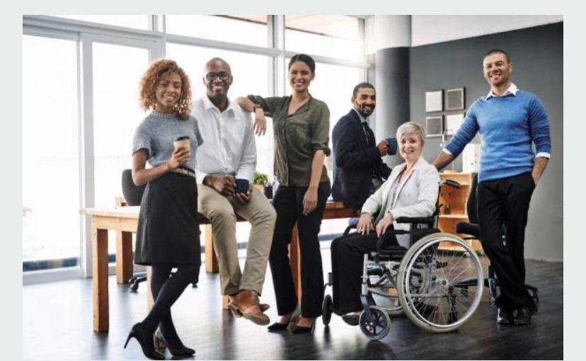 Group of employees seated, standing and in a wheelchair.