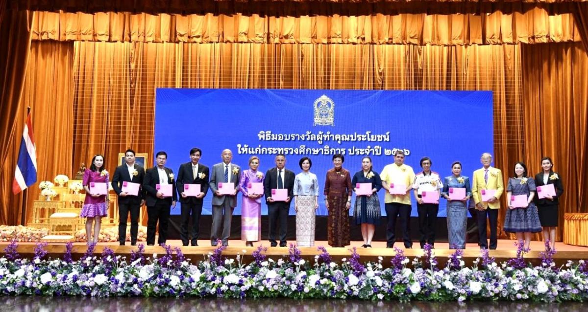 A line of people on a stage, holding certificates.