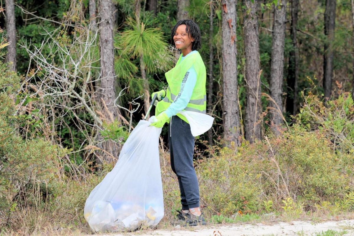 A volunteer smiles as she participates in the Fort Morgan clean-up.