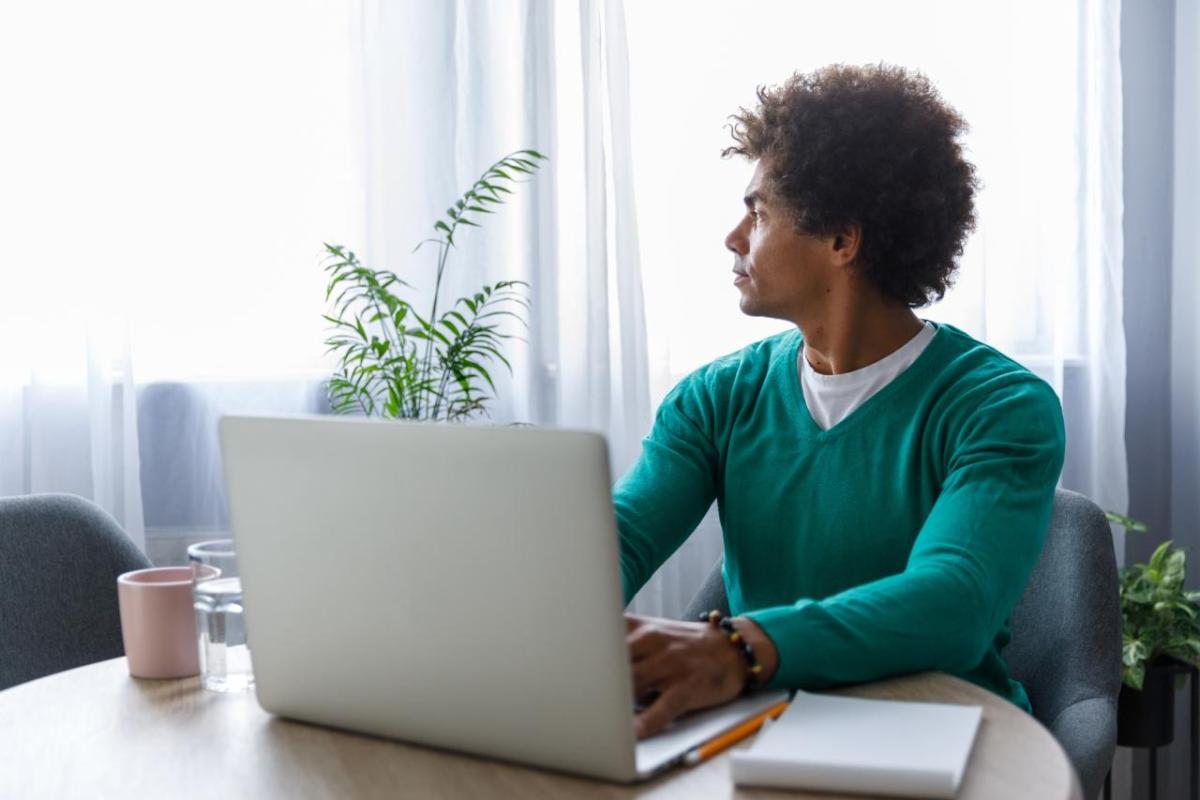 Man sitting at a desk looking towards a window