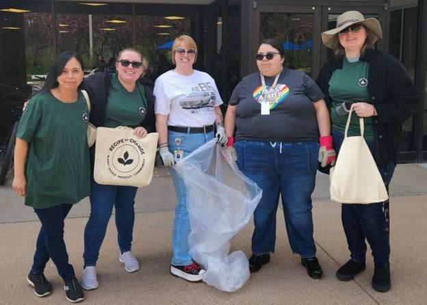 A group of people standing outside with trash bags