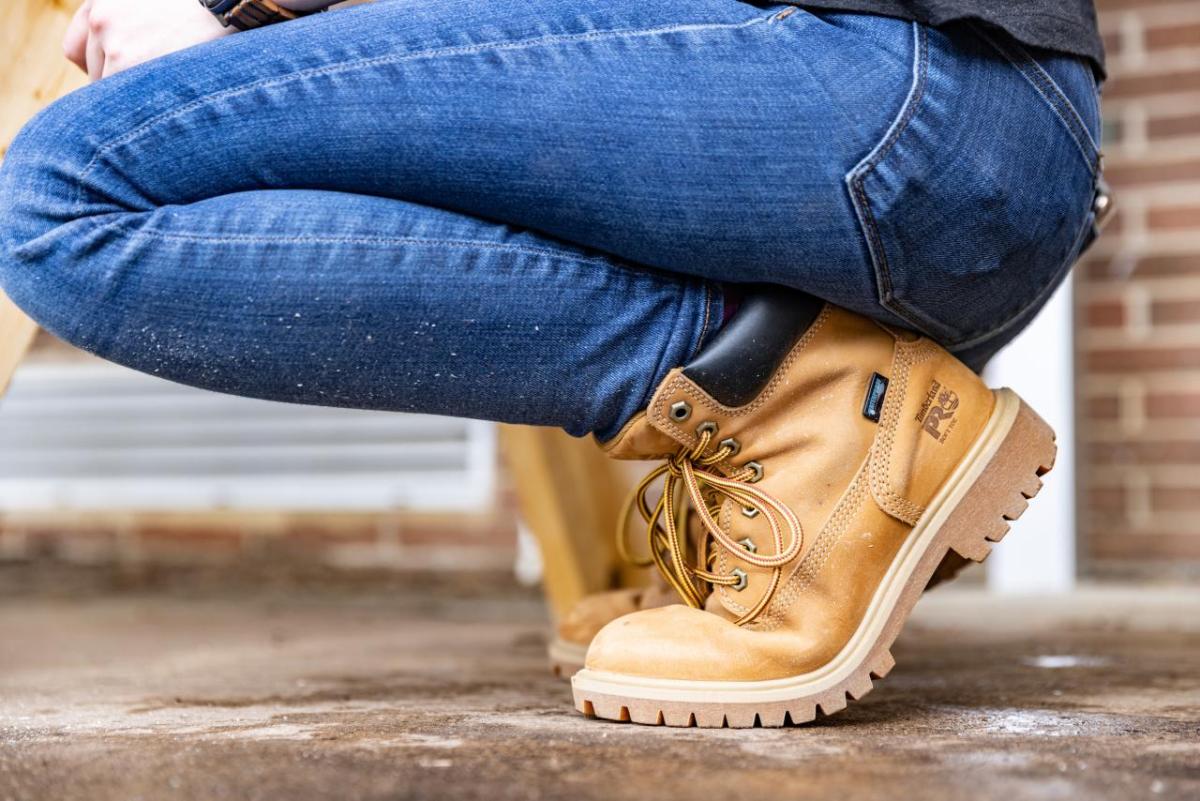 Person crouching down wearing jeans and Timberland boots