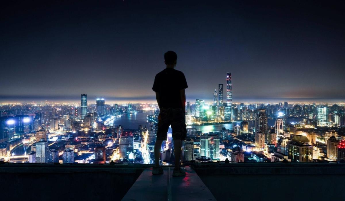 a human figure in silhouette overlooking a city skyline