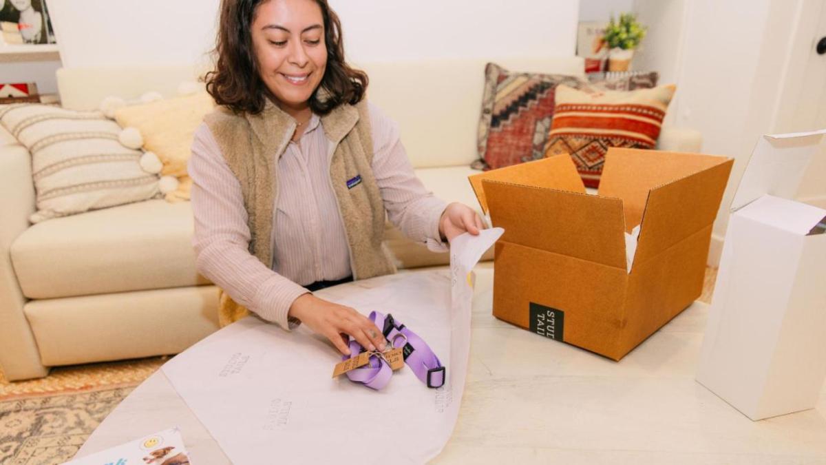 Person sat at a table packing an item 