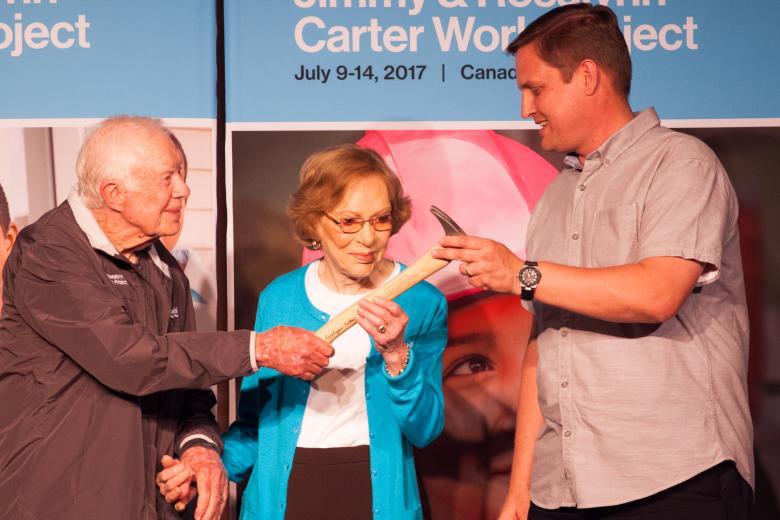 President and Mrs. Carter pass a hammer to Jim Williams, executive director of Habitat for Humanity of St. Joseph County, to announce Mishawaka and South Bend, Indiana, as the host sites for the 2018 Jimmy & Rosalynn Carter Work Project.