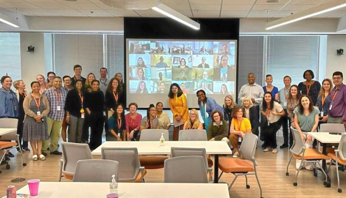 photo of team group standing in front of a screen
