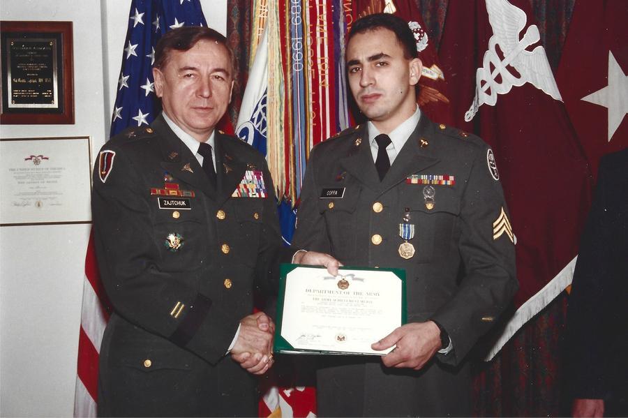 Jeff Coppa and another in military uniform as he receives an award.