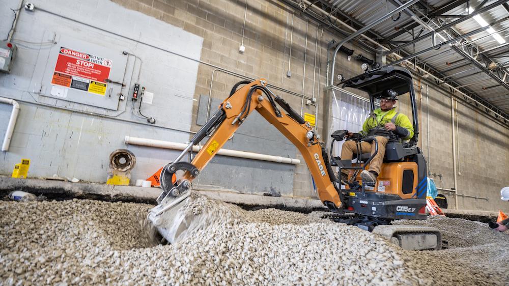 CX15EV electrified mini excavator digging in gravel