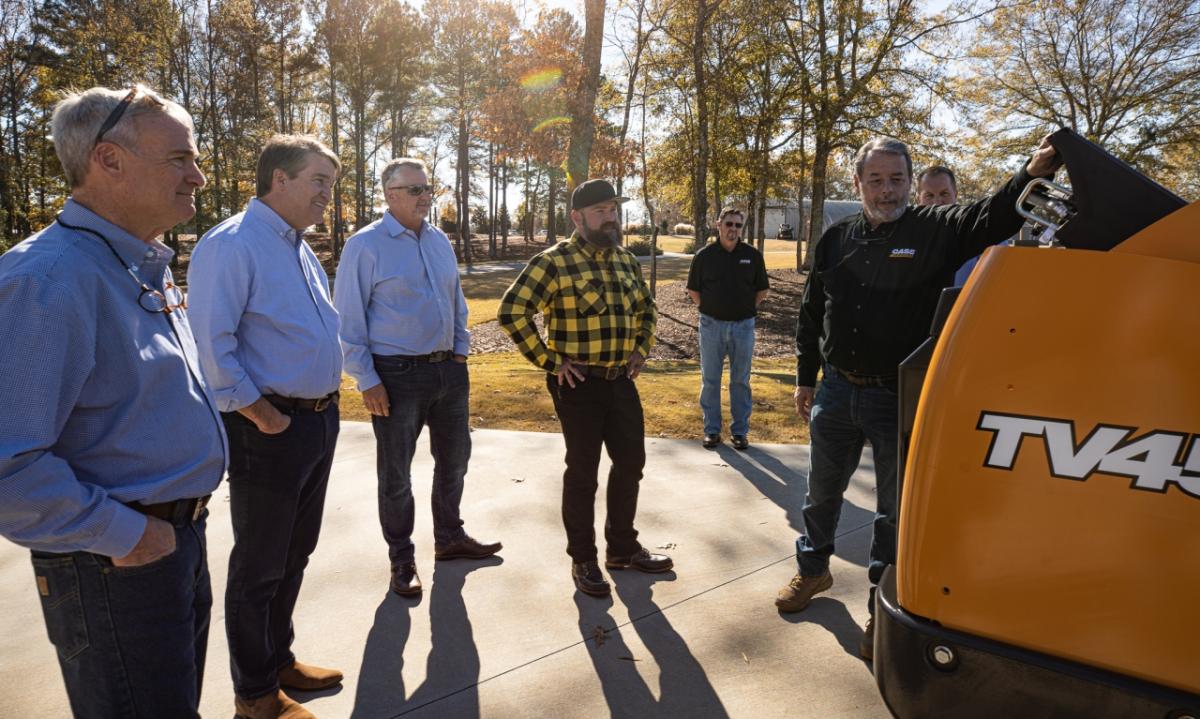 People gathered around a tractor being donated