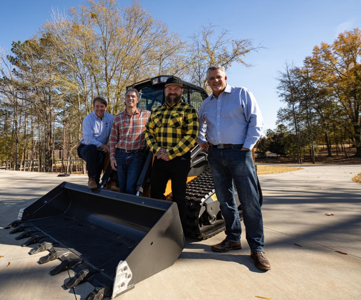 People gathered around a tractor being donated