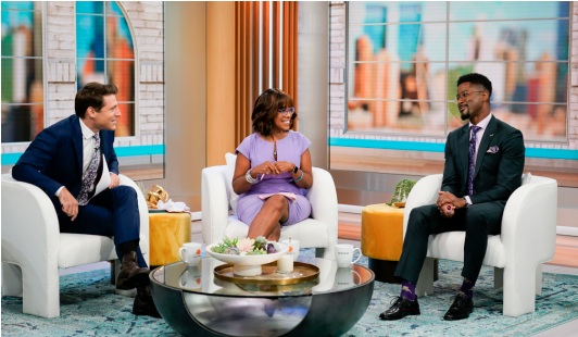 Three people in chairs on a news segment.