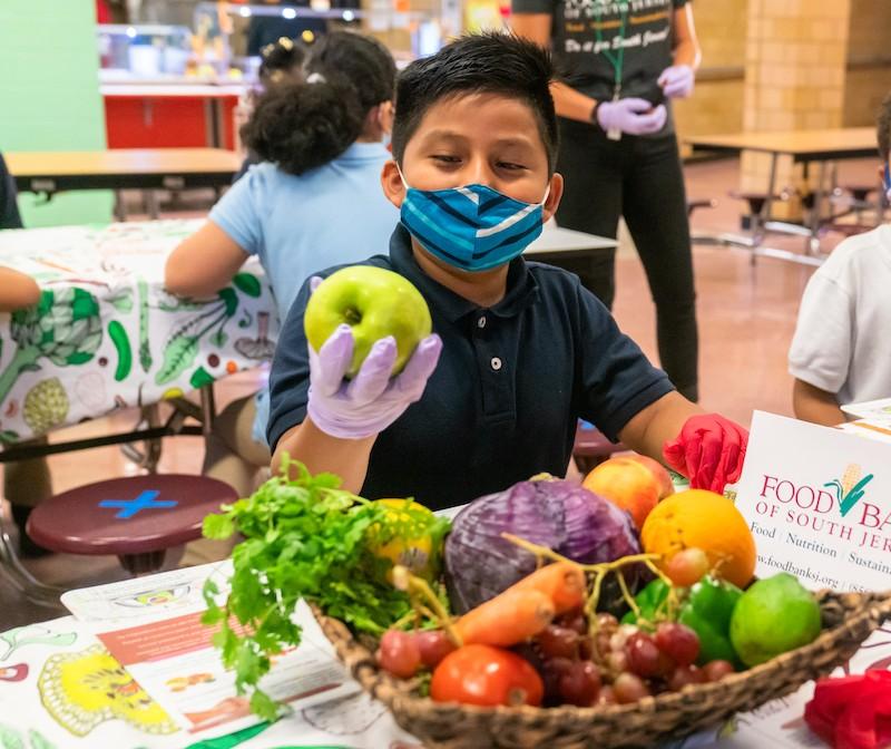 Photo courtesy of Campbell Soup Company Young boy in a mask holding an apple.
