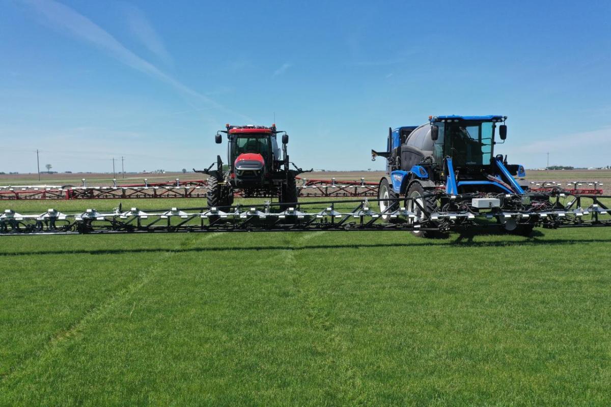 Two tractors spraying fields