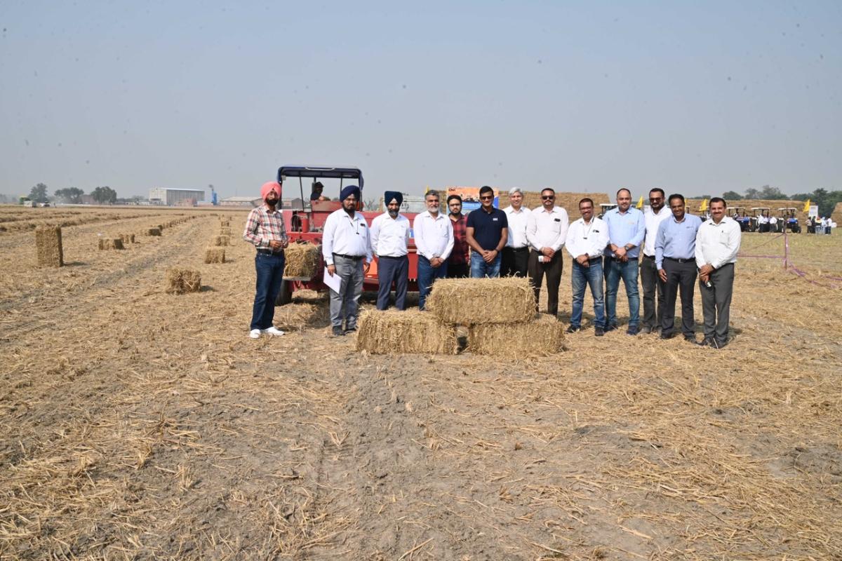 Punjab farmers standing behind bales of straw