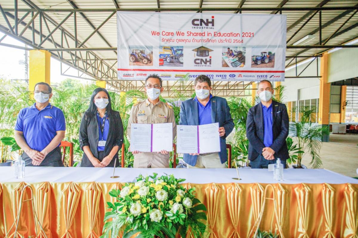 Five people standing at a table with CNH banner above them. Two of them are holding the MOU.