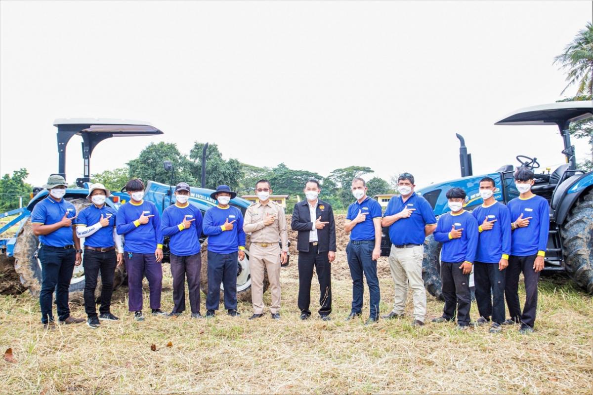 Group of people posing in front of two tractors