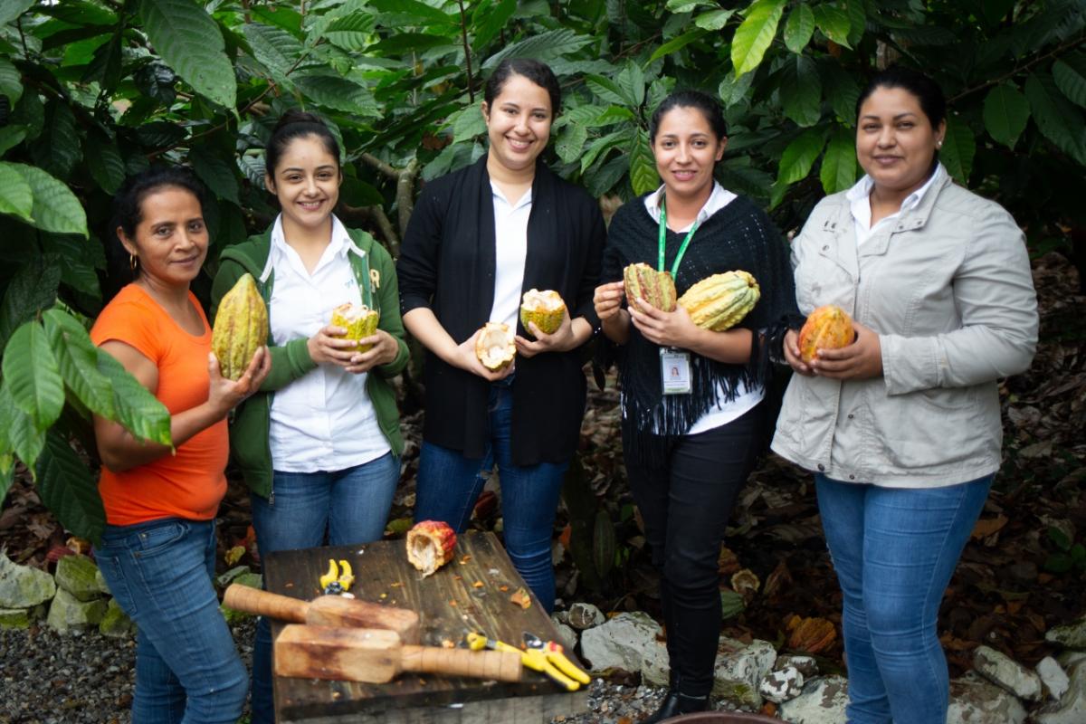 Rosa Maribel Cortes, Julibee Portillo, Alejandra Lemus, Julissa Medina and Sandra Buezo all work at the Xol chocolate factory in Honduras. Xol chocolate is a brand of the Fairtrade-certified COAGRICSAL coop, and the new factory in Honduras was built utilizing a Fairtrade Premium. The factory, the largest of its kind in the region, was built in response to the droughts and diseases caused by climate change. Rosa Maribel Cortes, Julibee Portillo, Alejandra Lemus, Julissa Medina and Sandra Buezo all work at the Xol chocolate factory in Honduras.