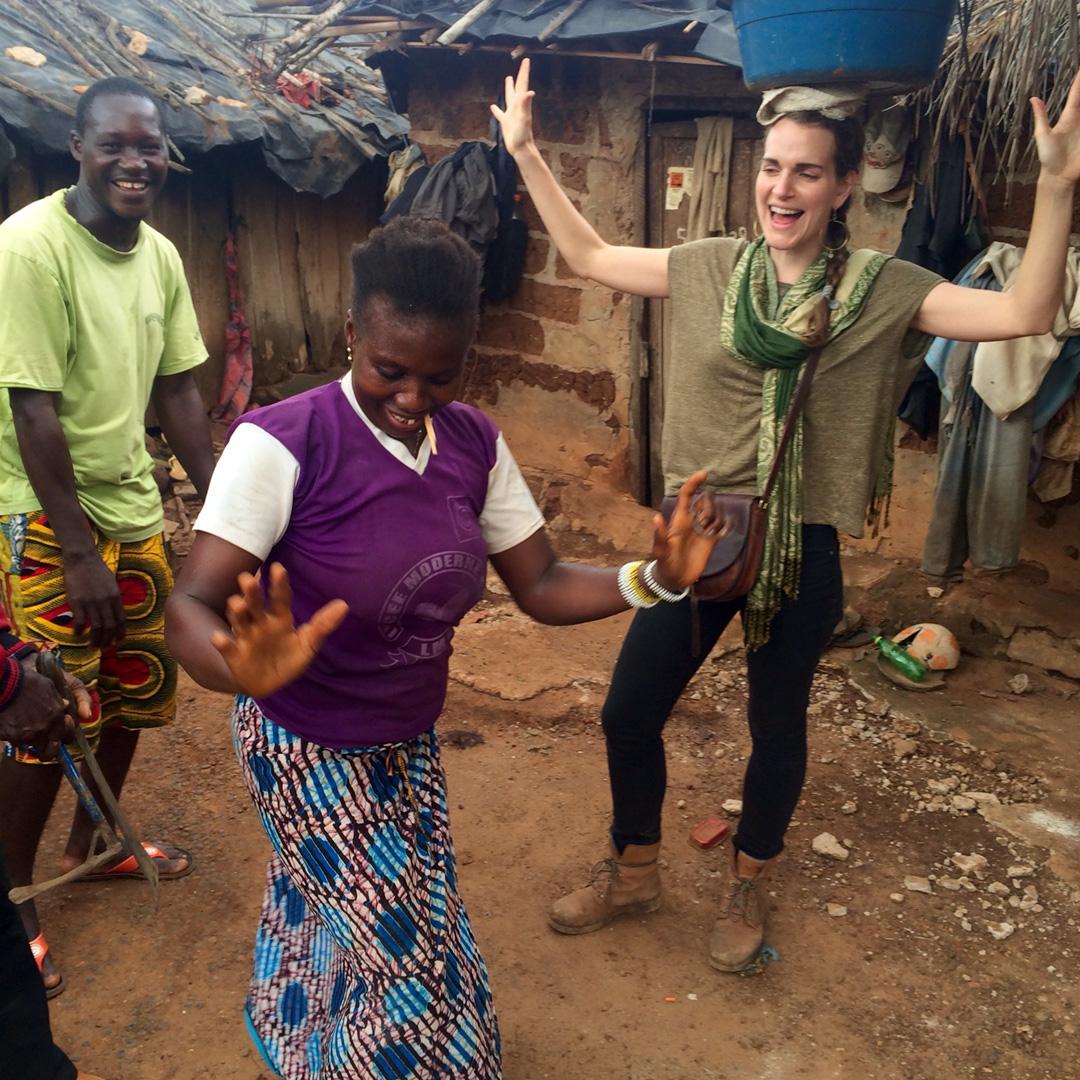 Laura Keen, Fair Trade USA Supply Chain Manager, dances with community members at a village in central Cote d'Ivoire.