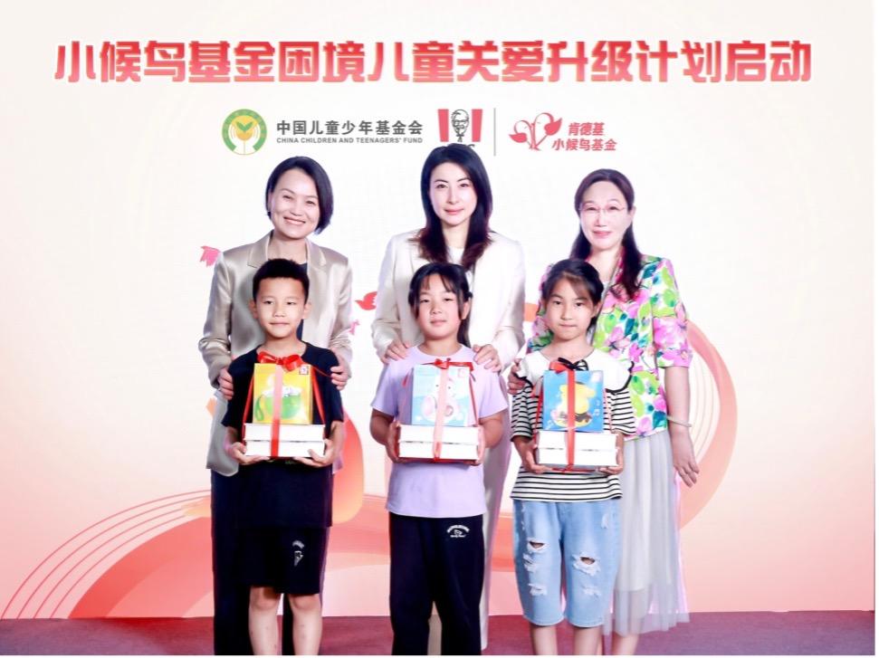 Three children standing with gifts in front of three adults