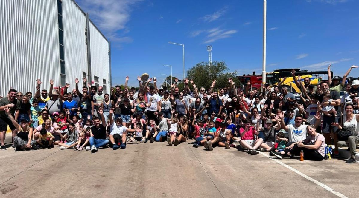 A large group posed outside, some with raised hands