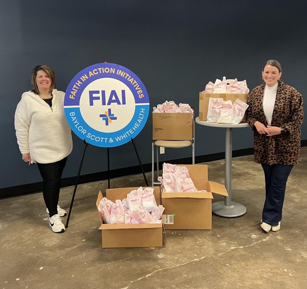 Two women standing next to boxes with gifts