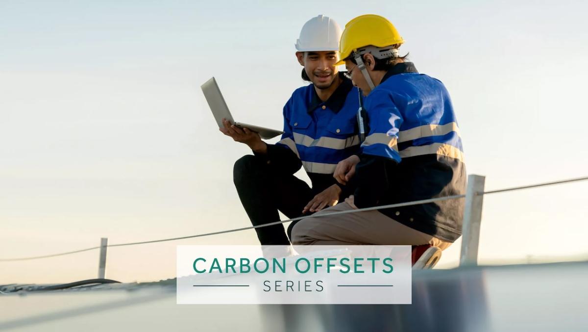 Carbon Offsets Series: Two technicians working on a solar panel.