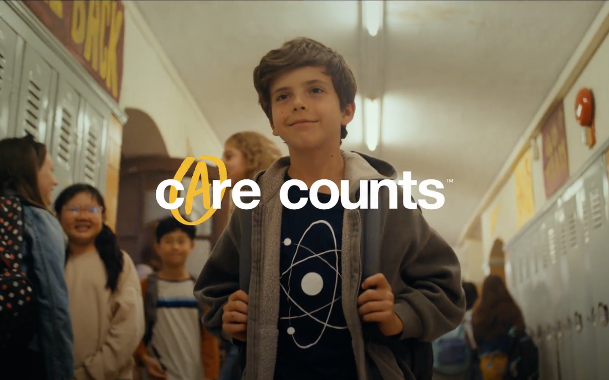 A photo of a child walking through a school corridor with the text 'Care Counts™'