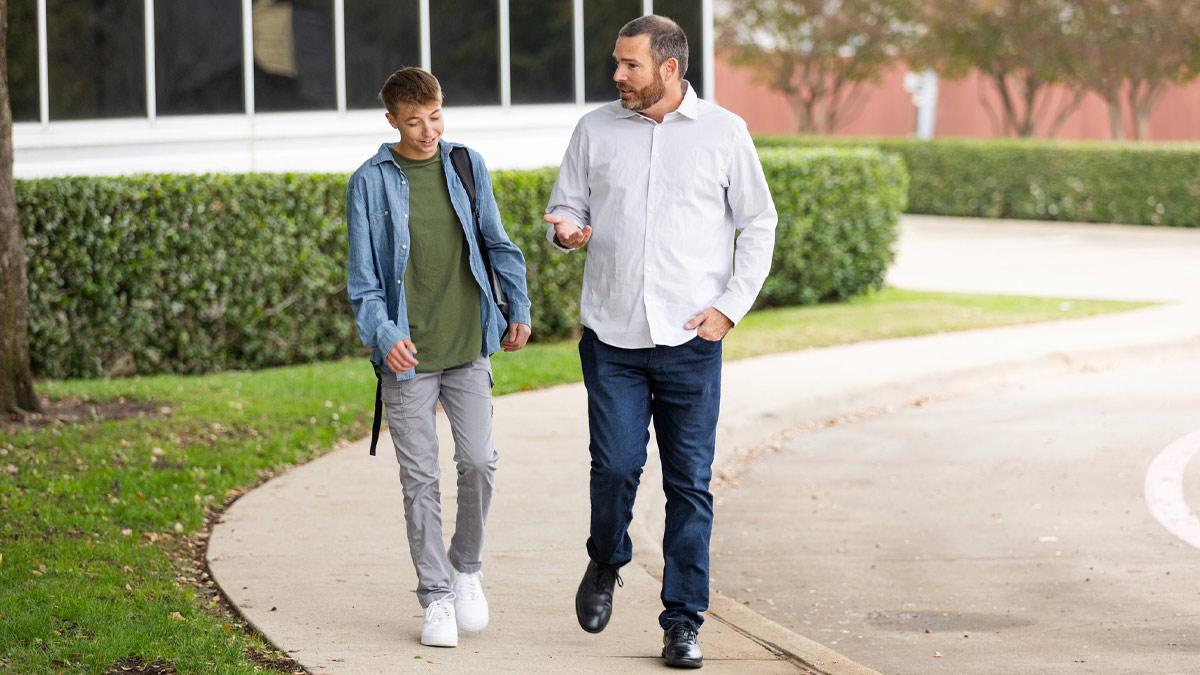 Father and son walking and having a conversation.