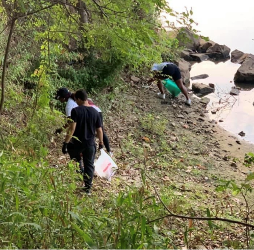 People by a river picking up trash